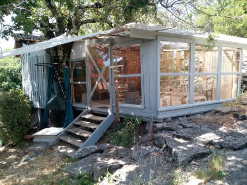 a screened in house with a porch and stairs at Chalet Banassac in Saint-Ambroix