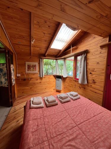 a bedroom with a large bed in a wooden room at ChacraKremen in El Bolsón