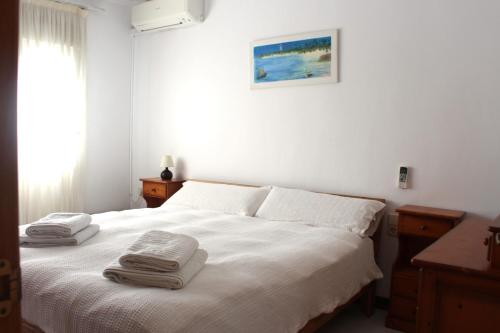 a bedroom with a white bed with towels on it at Villa Sol in Roquetas de Mar