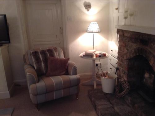a living room with a chair and a lamp at Birtles Farm Bed and Breakfast in Knutsford