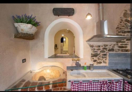 a kitchen with a large sink and a stove at Il Nuovo Vecchio Frantoio di Gardan Con Piscina in Vignana