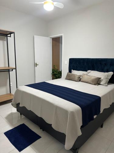 a bedroom with a large bed with a blue headboard at Vivendas do Paiol in Guapimirim