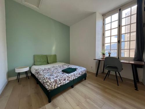 a bedroom with a bed and a desk and window at Maison en face du Marche Notre-Dame in Poitiers