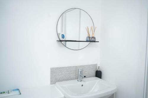 a bathroom with a sink and a mirror at Modern 2BR Home in Manchester in Manchester