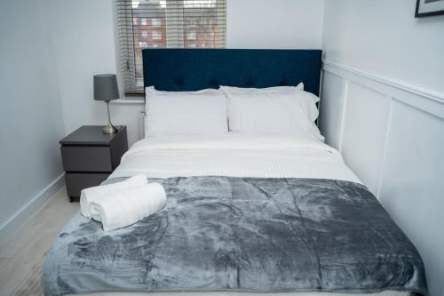 a bedroom with a large bed with a blue headboard at Modern 2BR Home in Manchester in Manchester