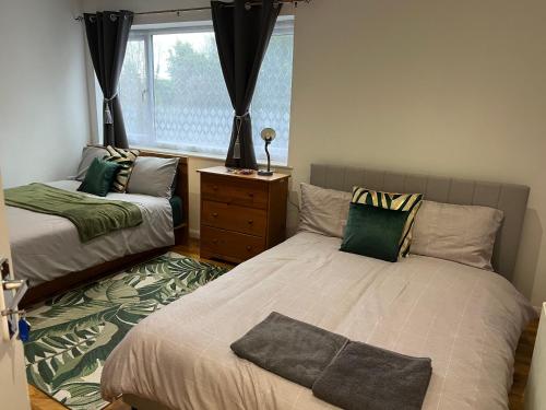 a bedroom with two beds and a window at Maxismile Haven in Southend-on-Sea