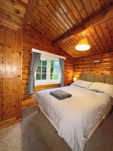 a bedroom with a bed in a log cabin at Snowdonia Escape in Trawsfynydd