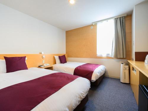 a hotel room with two beds and a window at hotel miura kaen in Takikawa