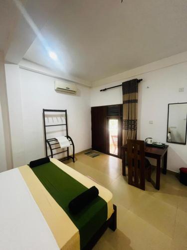 a bedroom with a bed and a desk and a chair at Sigiriya Yahana in Sigiriya