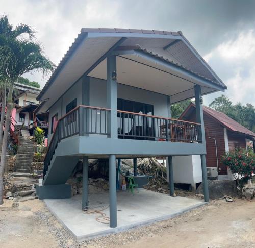 a house with a balcony and a staircase at Pimmada Hut in Haad Pleayleam