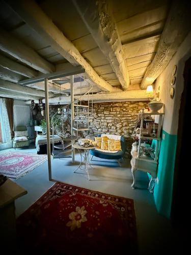 a living room with a couch and a stone wall at Viandanti, Artisti e Sognatori in Comano