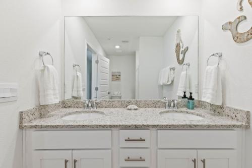 a bathroom with two sinks and a large mirror at Family home near boat launches, beaches, and The Wharf! King bed and pet friendly in Orange Beach
