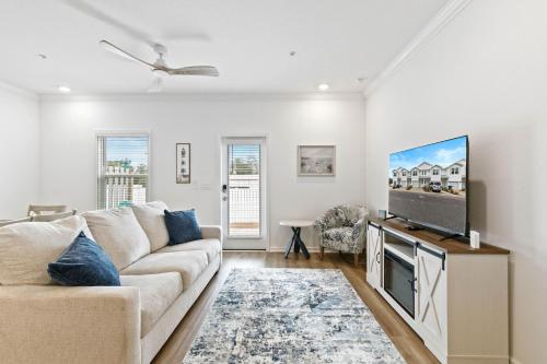 a living room with a couch and a flat screen tv at Family home near boat launches, beaches, and The Wharf! King bed and pet friendly in Orange Beach
