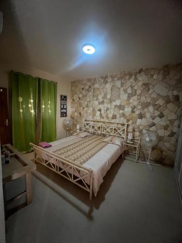 a bedroom with a bed and a stone wall at Villa La beauté luxueuse in Rufisque