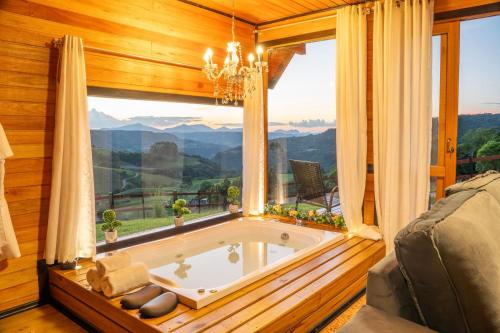 a jacuzzi tub in a room with a window at Vale Encantado Alfredo Wagner in Alfredo Wagner