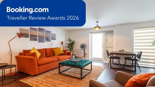 a living room with an orange couch and a table at Stay@Coast in Bournemouth
