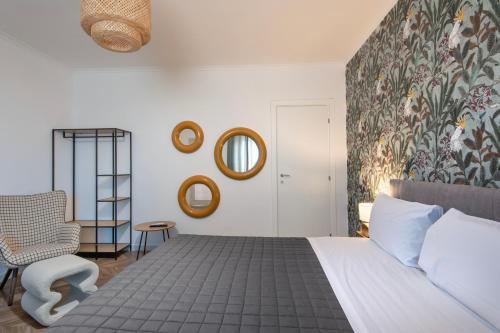 a bedroom with a bed and a chair and mirrors at Enia Rooms in Nola