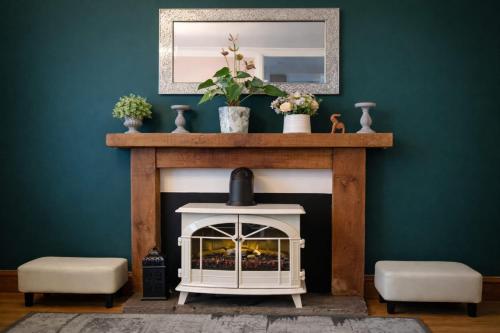 a fireplace in a living room with a green wall at Walk to Town, Parking, Family Home, drive to beach in Bridgend
