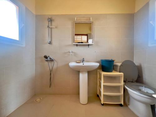 a bathroom with a sink and a toilet at Villa La beauté luxueuse in Rufisque