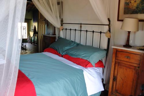 a bedroom with a bed with blue and red sheets at La Balconata in Bagni di Lucca