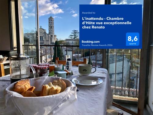 a table with a basket of bread on a table with a window at L'inattendu - B&B - Chambre d'Hôte vue exceptionnelle in Uzès