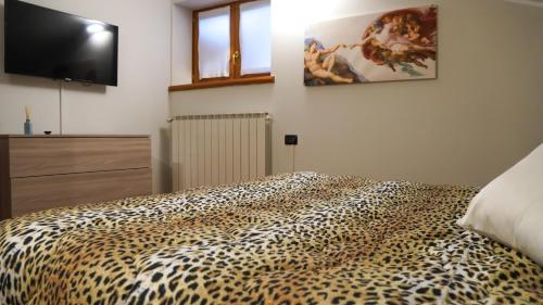 a bedroom with a leopard print bed and a flat screen tv at Eden Apartment di Manenti Andrea in Oltre il Colle