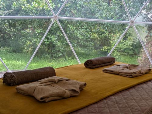 two blankets on a bed in front of a window at Teapot Lane Glamping - Adults only in Sligo