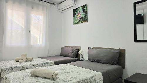 a room with two beds and a window at GOLDEN TOWER pensión Auto Check-in in Gandía