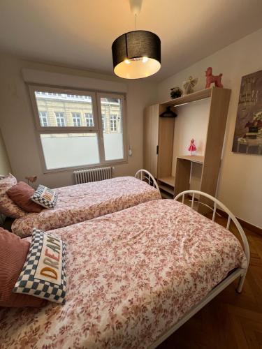 a bedroom with two beds and a mirror at Centre ville 2 chambres 4 voyageurs Tarif long séjour in Valenciennes