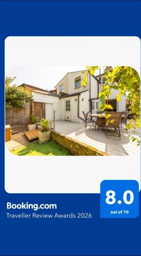 a view of a house with a patio with a table at Charming 3BR Victorian House with Parking - 10 Mins to Kingston in Kingston upon Thames