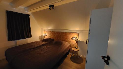 a small bedroom with a bed and a window at Gramsbergs Huuske in Gramsbergen