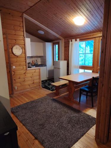 a kitchen and dining room with a table in a cabin at Riihitupa 10 in Muurame