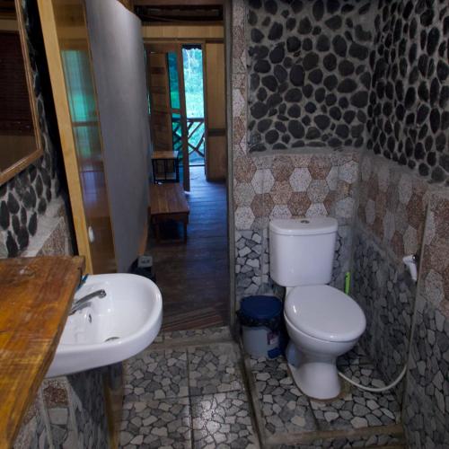 a bathroom with a toilet and a sink at La Capanna Sumatra Ecovillage in Timbanglawang
