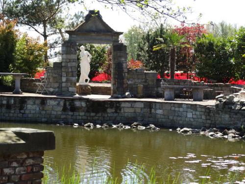 a statue next to a pond in a park at Paradijs Eiland in Hillegom
