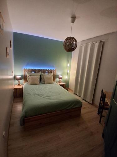 a bedroom with a large bed with a blue wall at Les Logis de Léa in Saint-Beauzély