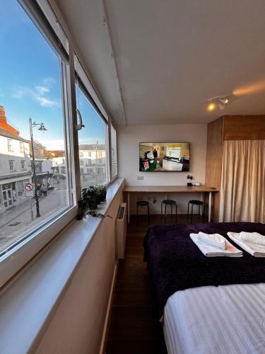 a room with two beds and a large window at Studio with Parking & Shops at Your Door in Andover