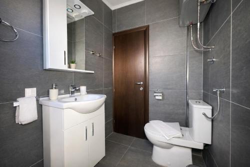 a bathroom with a toilet and a sink and a mirror at Villa Sun Budva in Budva