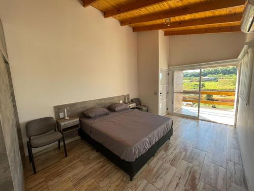 a bedroom with a bed and a chair and a window at Tierra Roja in San Vicente