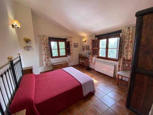 a bedroom with a bed and a table and windows at Apartamentos en finca privada in La Borrega