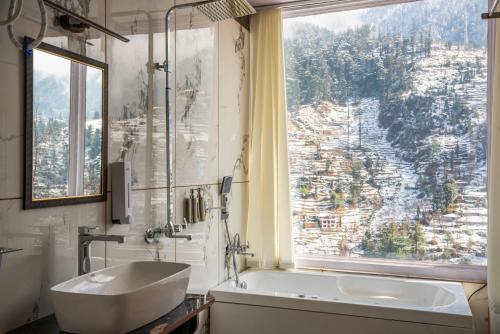 a bathroom with a tub and a sink and a window at Sunrise Farm Stays in Jibhi