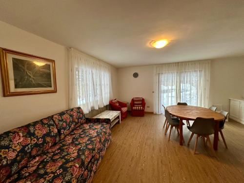 a living room with a couch and a table at Central Dolomites Atelier - 3 Bedrooms in Campitello di Fassa