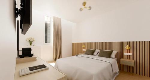 a bedroom with a bed and a desk with a laptop at Hotel le Romanesque in Cannes