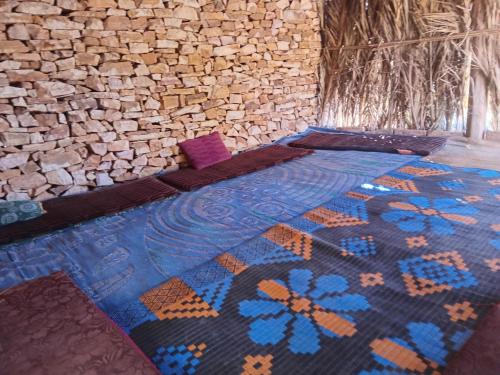 TerjitにあるAuberge Tembahjitのレンガの壁のある部屋にあるベッド