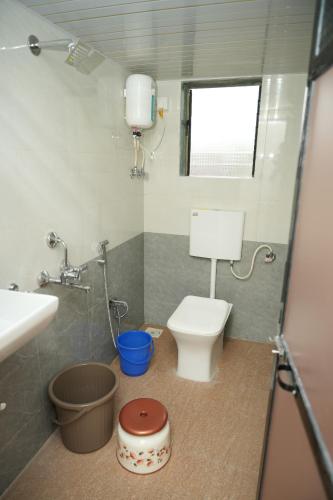 a small bathroom with a toilet and a sink at Swayam Beach Nivas in Srīvardhan