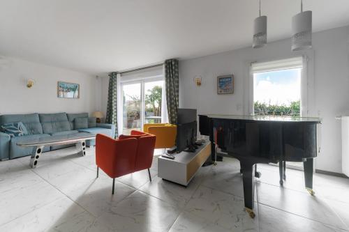 a living room with a couch and a piano at Maison Grillon - Maison proche de Vichy avec piscine in Abrest