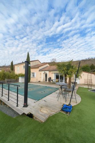a backyard with a swimming pool and a house at Maison Grillon - Maison proche de Vichy avec piscine in Abrest