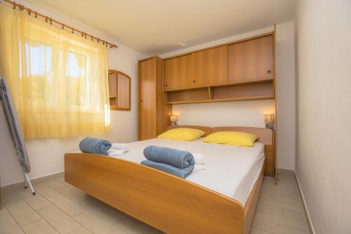 a bedroom with a bed with two towels on it at Apartmani Jurin in Primošten