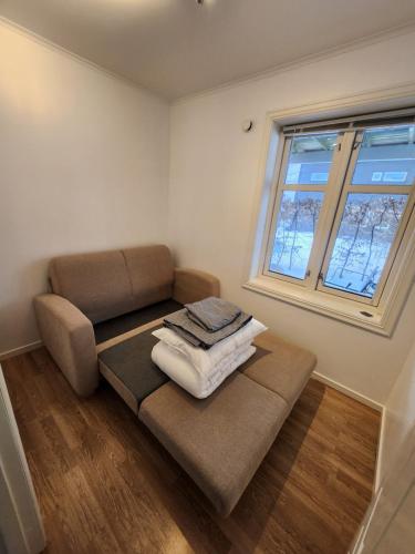 a living room with a couch and a window at Kalveld aparment 2 in Lillesand