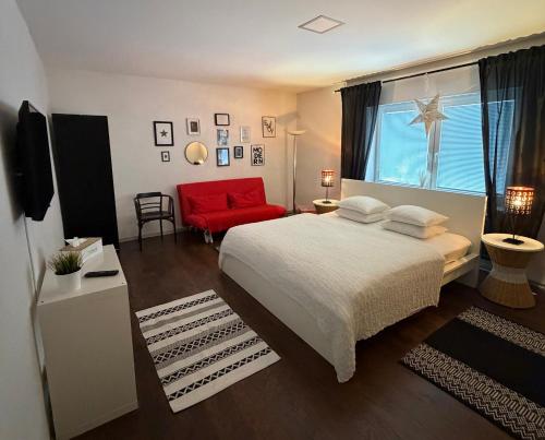 a bedroom with a large bed and a red chair at Apartments Centrum in Rožnov pod Radhoštěm
