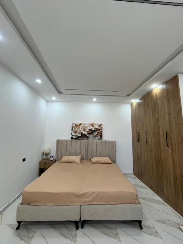 a bedroom with a bed and a wooden cabinet at issac in Monastir
